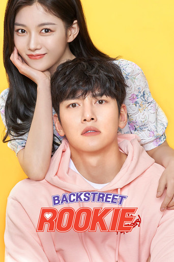 The poster features two young people against a vibrant yellow background, with one sitting on a stool and the other standing beside a pink basket. The bold red and blue title "BACKSTREET ROOKIE" dominates the foreground, evoking a youthful, energetic, and slightly rebellious mood.