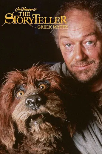The Storyteller: Greek Myth poster features a man with a warm, inviting smile and a fluffy dog with expressive eyes. The dark background highlights the golden title text, creating an atmospheric and mysterious mood.