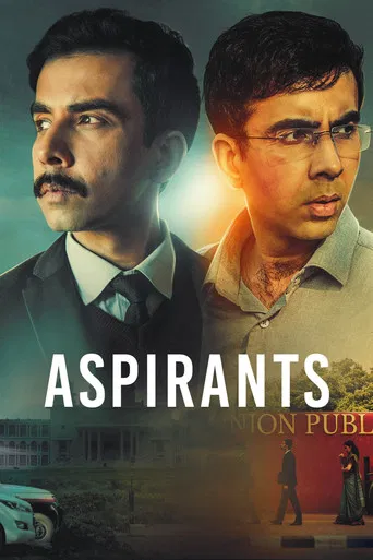 The poster features two men with intense expressions against a dramatic backdrop of warm and cool tones. The title "ASPIRANTS" is prominently displayed in bold white letters, suggesting themes of ambition and struggle. The overall mood is intense and mysterious, hinting at a high-stakes narrative...
