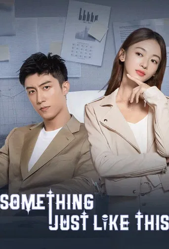 The poster features a stylish couple in beige tones, with the man in a sharp suit and the woman in a soft blazer. The mood is casual yet sophisticated, with the man looking directly at the viewer and the woman leaning back with a thoughtful expression. The background includes a wall with papers a...
