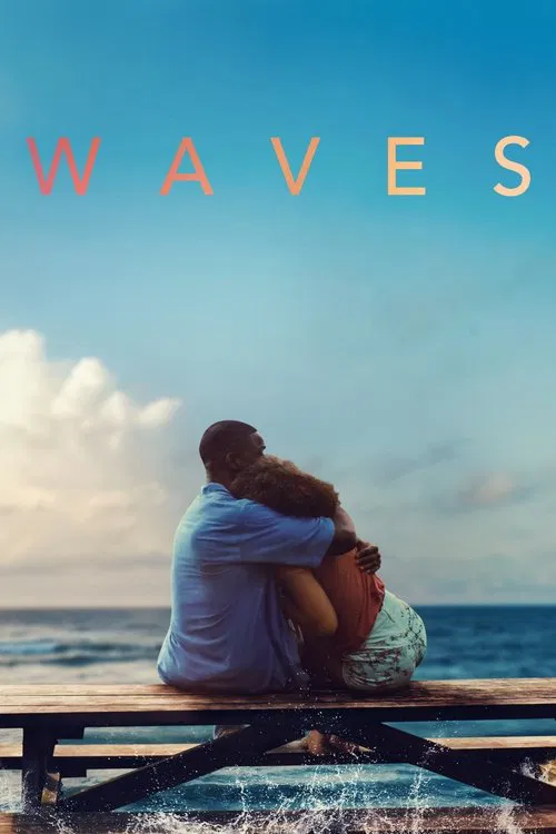 A couple sits huddled on a wooden pier, embracing as the ocean waves crash against the shore. The warm tones of their clothing blend with the soft blues of the sky and water, evoking a sense of quiet intimacy and natural beauty.