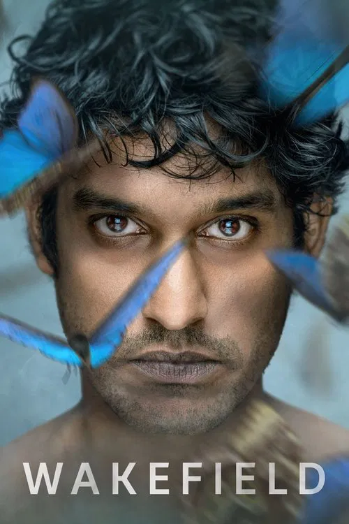 This TV show poster for "Wakefield" features a close-up of a man with dark, tousled hair and intense eyes, framed by vibrant blue butterflies. The mood is mysterious and dramatic, with the title "WAKEFIELD" prominently displayed at the bottom.