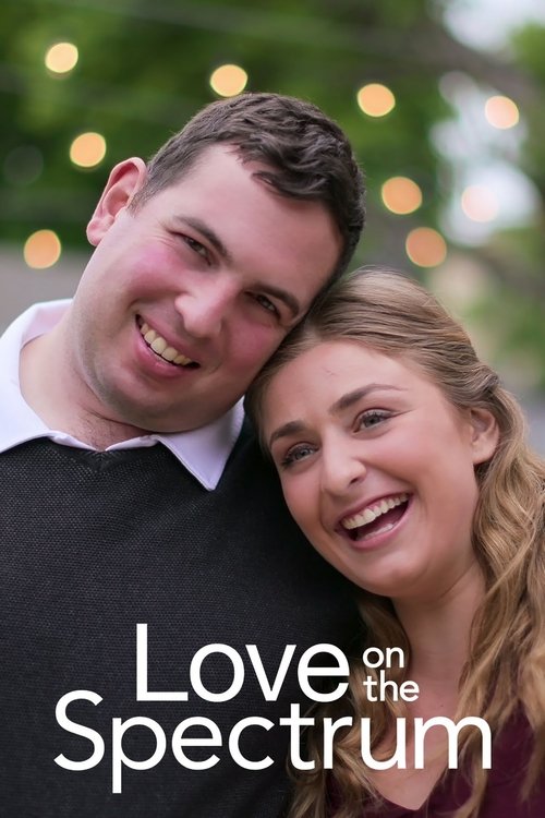 A couple shares a warm, intimate moment against a softly blurred backdrop of twinkling lights. The soft glow of the lights and their joyful expressions convey a romantic and hopeful atmosphere.