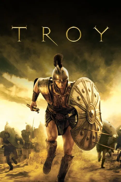 The poster features a muscular warrior with golden hair and armor, holding a spear against a dramatic sky. The word "TROY" glows in gold lettering, evoking a sense of epic adventure and historical drama.