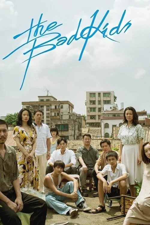 The poster features a group of diverse young people in casual attire, sitting and standing in front of a backdrop of colorful buildings. The vibrant blue title text "The Bad Kids" stands out against the sky, suggesting a lively, possibly comedic tone. The overall mood is relaxed and youthful, cap...