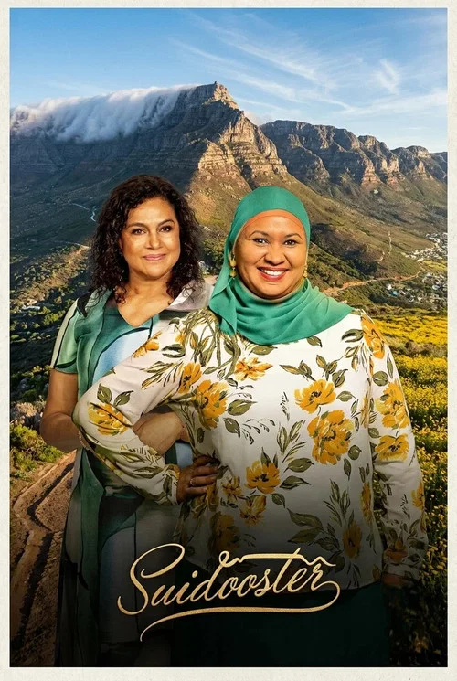 The poster features four smiling people standing in front of a dramatic canyon landscape with purple skies. They are surrounded by vibrant purple flowers, creating a cheerful and inviting atmosphere. The title "Suidooster" is elegantly written in white script at the bottom, emphasizing the show's...