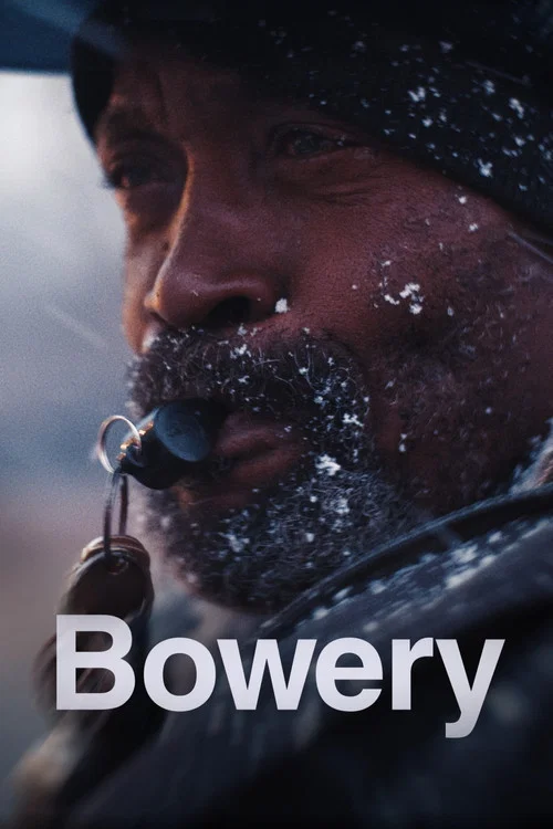 The poster features a rugged man in a dark hat and scarf, covered in snow, with a key hanging from his collar. The muted, wintry colors and gritty atmosphere convey a sense of hardship and resilience.